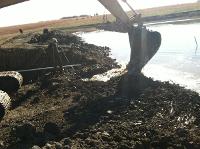 A closer look at how the excavator is digging into the dam front.