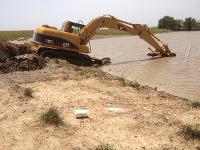 The excavator is locating the pond depth at the end of its reach.