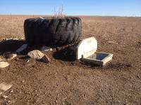 Tire prevents cattle from wearing away the soil from on top of the waterer 