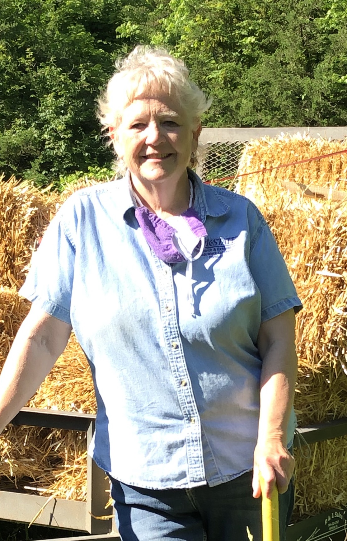 Jody Holtaus, standing in front of a flatbed with bales of barley straw