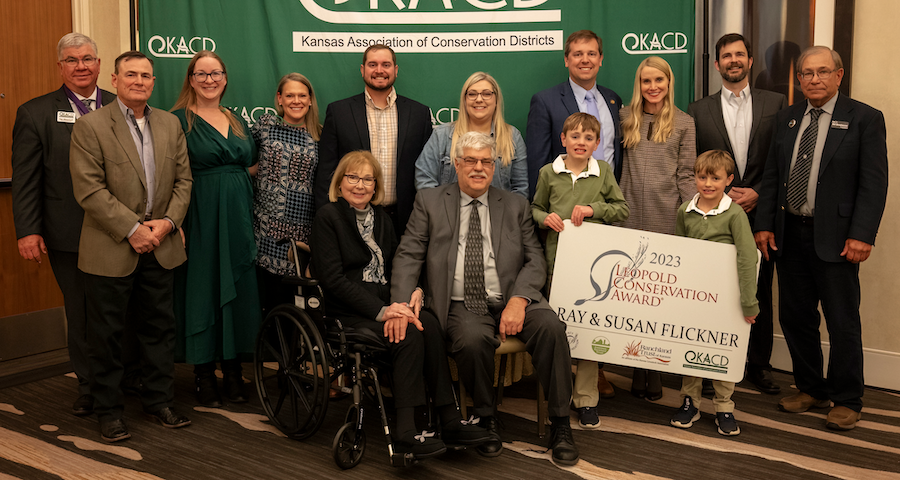 The Flickner Family, KACD representatives, and KCARE team members pose with the Leopold Award sign