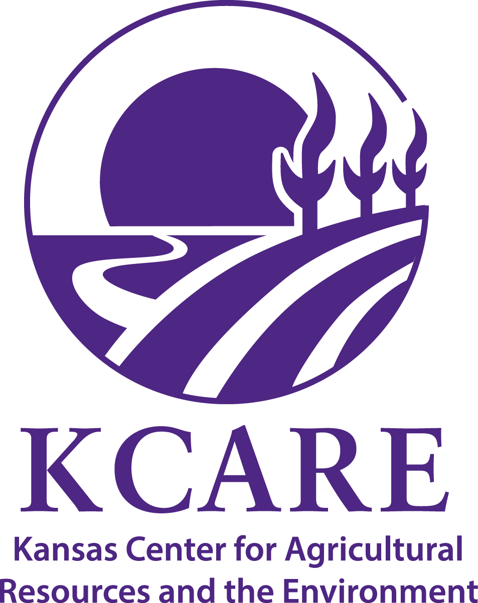 A purple circular logo, with a rising sun behind a graphic representing a river and a field of corn, underneath is written KCARE